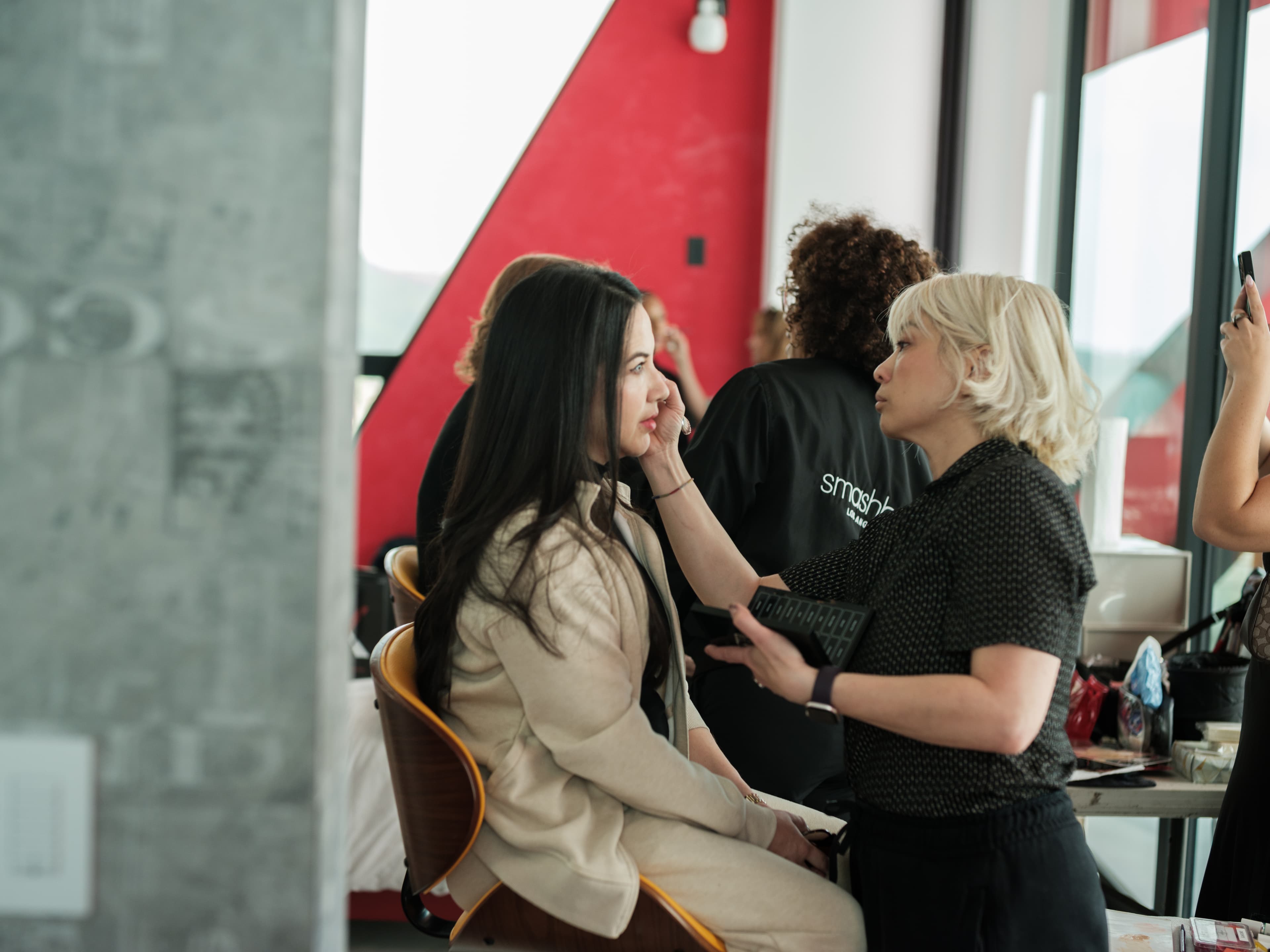 Makeup artist applying donated beauty products backstage
